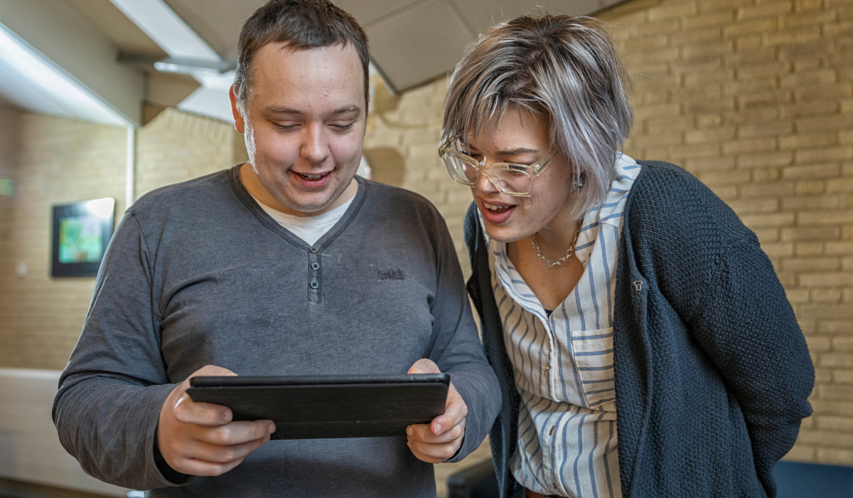 Twee mensen kijken naar een tablet