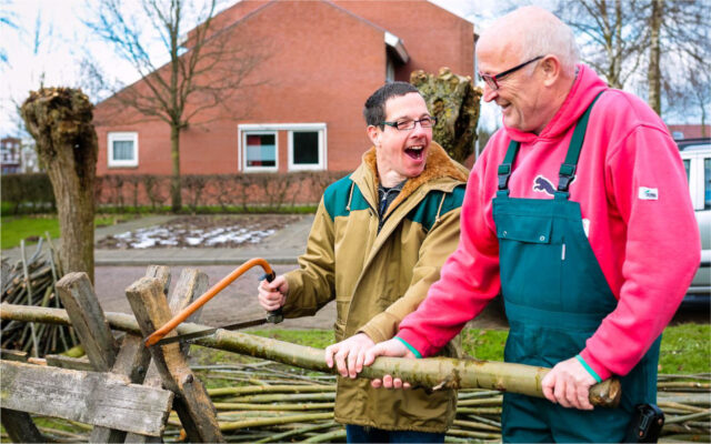 Medewerker en bewoner van Sovak werken in de tuin