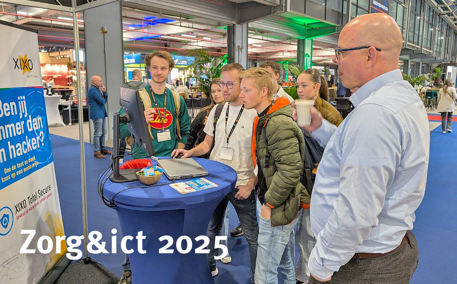 Groepje jonge mensen staan rondom een laptop op de Zorg & ICT beurs met man in lichtblauw overhemd die toekijkt